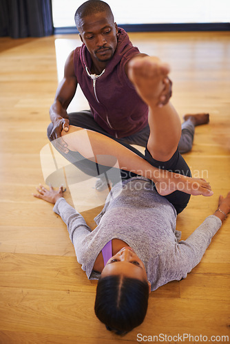 Image of Dancer, coach and stretching with help for legs in class for warm up, fitness or muscle on floor. Man, woman and support for dancing, workout or ready to start with creativity in studio for exercise