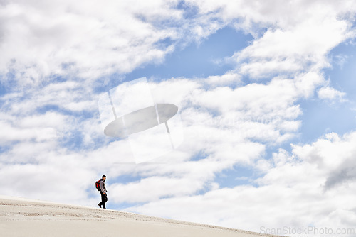 Image of Hike, dunes and sky with male person in nature for adventure, walk and desert landscape with clouds. Fitness, travel and nomad man people in Sahara, outdoor and hiking in dry climate and scenery