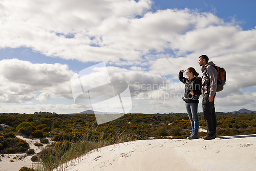 Image of Sand dunes, nature and couple hiking for adventure, desert and travel on outdoor holiday for love or view. Hill, explorers walking and nomad people in Sahara terrain experience, trip or dry climate