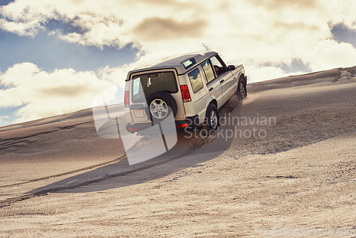 Image of Car, desert and drive with travel and transportation outdoor, off road vehicle for sand dunes and journey on vacation. Van, 4x4 or SUV with adventure, exploration and destination for tourism in Dubai