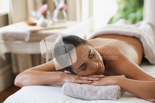 Image of Spa, treatment and zen woman on massage table, salon and beauty therapist in wellness centre. Peaceful, smile and reflexology for body and relax, pamper and skin care for sleeping female client