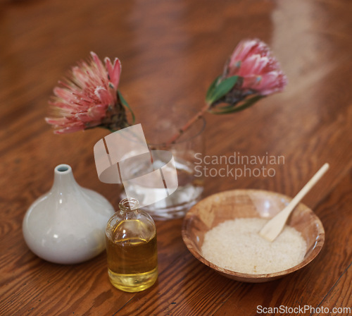 Image of Hotel, aromatherapy or spa with flowers, oil for zen, calm or peace to relax for health or natural healing. Protea plant, wellness or salt for wellbeing, holistic massage or hospitality background