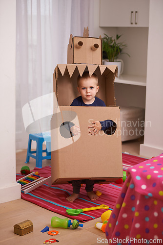 Image of Child, box and play for robot and imagination in bedroom for fun and recreation in home on weekend. Young kid, toddler and innocent with costume for development and cute for toy and childhood