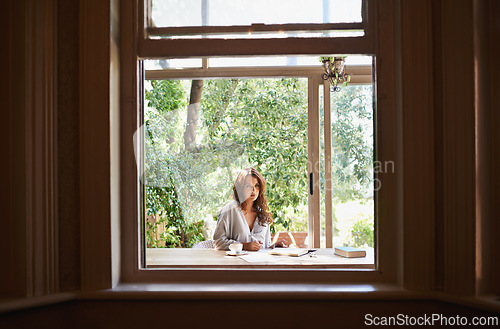 Image of Window, nature and woman person journaling in home, porch or sun room for relax. Spring, writing and reading with coffee in house with greenery, author or female writer with books and notepad