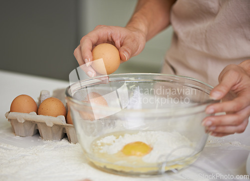 Image of Hands, person and eggs with bowl, kitchen and flour for baking with whisk. Baker, muffin and food with countertop, apron and mixing for recipe preparation and recreation or hobby at home or house