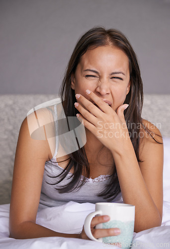 Image of Woman, yawn or coffee in bed for energy to wake up in peace, morning routine for mental health. Tired, sleepy or female person in cozy, comfort or warm for tea as soothing, self care or stress relief