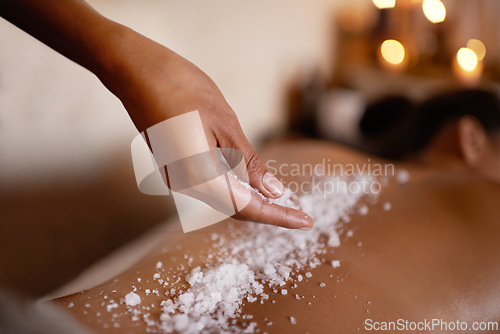 Image of Hand, massage and salt with woman at spa on bed or table for luxury pamper treatment closeup. Relax, wellness and back of customer at beauty resort or salon for holistic therapy or exfoliation