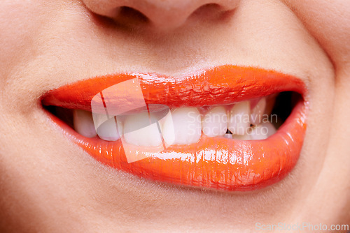 Image of Lipstick, beauty and bite lip of woman for makeup, cosmetics and products for flirt or seduction. Salon, cosmetology and closeup of face of person with red lip gloss, shine and creative aesthetic