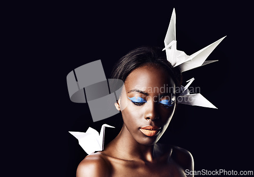 Image of Black woman, makeup and fine art with beauty, dove or origami birds on a dark studio background. Closeup or face of African female person or model with creative cosmetics or eyeshadow on mockup space