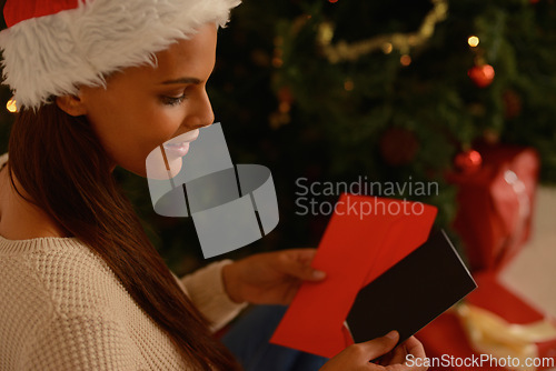 Image of Happy woman, christmas tree and letter with card for message, wishes and care on holiday season in home. Person, smile or note by present for xmas greeting, gratitude or kindness in spirit of giving