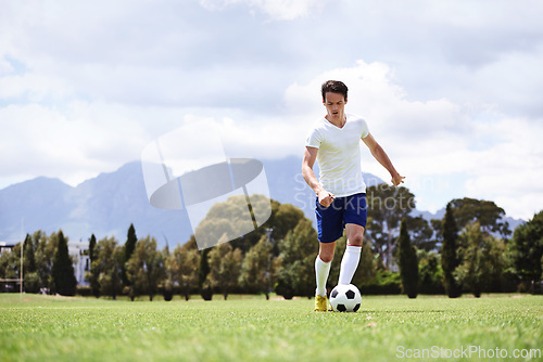 Image of Man, soccer player and dribble with ball on field for moving, speed or skills in low angle at club on training ground. Person, football and sport with exercise, steps and workout for fitness in game
