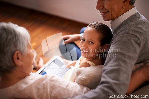 Image of Child, grandparents and tablet on couch in home or online game or communication, teaching or connection. Elderly couple, retirement and girl or internet learning in apartment, development or bonding