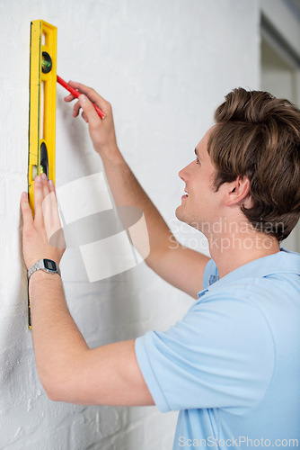 Image of Man, level wall and home for measurement with smile for renovation, maintenance and decoration with tools. Construction, house and handyman as contractor with marker for improvement and interior