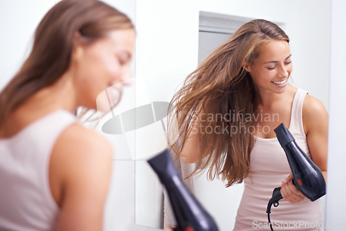 Image of Hair care, smile and woman with blowdryer in bathroom for salon, cosmetic and conditioner treatment. Beauty, happy and female person with healthy hairstyle routine with heat tool at modern home.