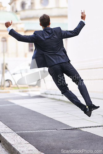 Image of Business, excited and man jump with phone in city street celebration for wow, news or winner fist gesture. Smartphone, energy or entrepreneur back with app alert for online competition prize or lotto
