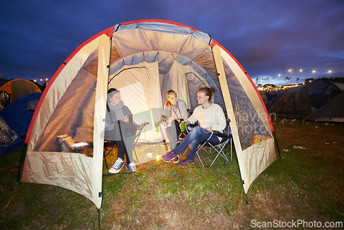 Image of Happy woman, friends and night in tent at festival for party, event or carnival on outdoor campsite. Female person, people or group in relax or camping in the late evening with drinks and candlelight