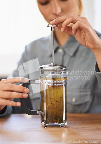 Image of Woman, closeup or herbal tea to relax in home and warm beverage of herbs mixture in plunger for health. Herbalist, drink or creative idea for dry leaves and wellness for detox liquid on kitchen table