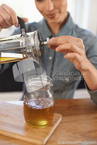 Image of Closeup, woman and hands with brewing tea to start morning, cafe and table before work. Plunger, pouring and healthy beverage in jug for customer, breakfast and drink to enjoy beautiful day.