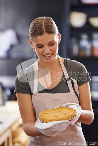 Image of Happy, woman and pie in kitchen at bakery with chef in restaurant cooking a lunch. Person, smile and food in hands of baker with pride and confidence in skill of baking pastry dish for dinner