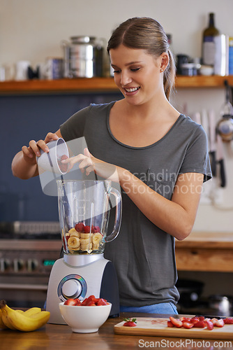 Image of Kitchen, happy woman and blender for fruit smoothie, nutrition or food for healthy diet at table in home. Person, smile and mixer for drink, juice or strawberry for wellness with organic beverage
