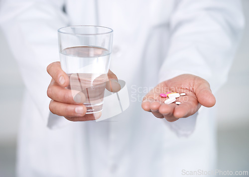 Image of Medicine, pills and water in hands of doctor in clinic or hospital to offer of healing healthcare. Medical, drugs or person giving pharmaceutical supplements to drink as cure for pain of sick patient