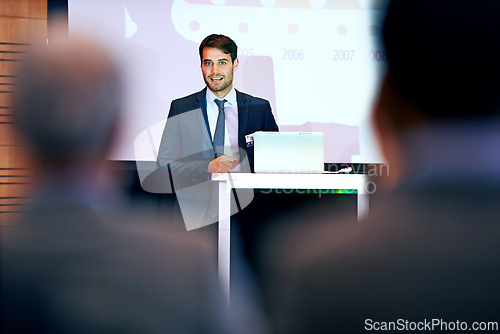 Image of Business man, podium and presentation with projector screen, conference or workshop with laptop for slideshow. Corporate training, seminar and speaker with info, audience and professional speech