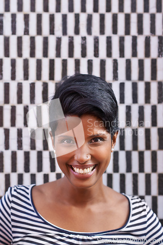 Image of Woman, portrait and smile with pattern, happiness and urban style for optimism. Person, fashion and excited for summer, satisfaction and positive natural beauty on trendy checkered wall background