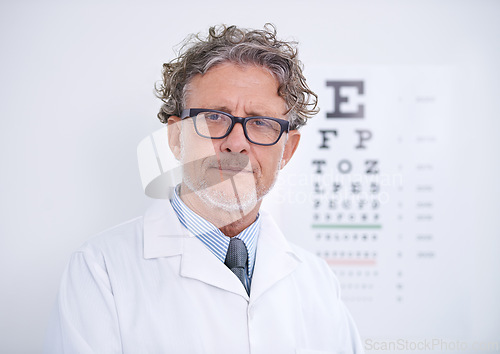 Image of Test, eye and portrait of optometrist in clinic with glasses to check vision and exam in healthcare. Mature, doctor and reading letters on wall in medical assessment for contact lenses or eyesight