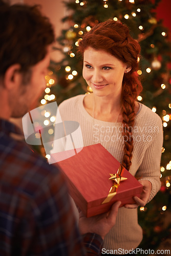 Image of Couple, Christmas and gift for holiday celebration, festive and season of giving for love and commitment. Happy, gratitude and support with people at home for present, romance and relationship