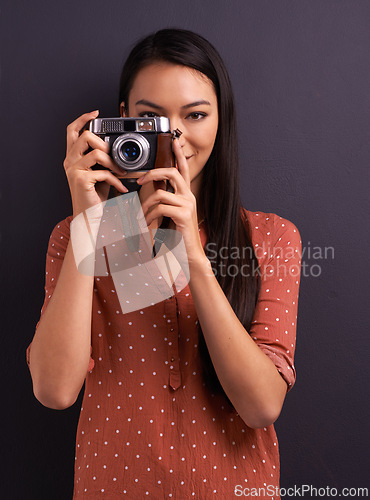 Image of Happy woman, portrait and photography with camera for memory or picture on a dark studio background. Young female person or creative journalist with smile for photo, moment or capture for startup