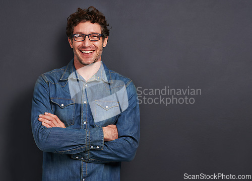 Image of Studio, portrait and man with smile, glasses and casual fashion on mockup space for creative professional. Relax, happy and person with confidence, pride and trendy denim style on dark background