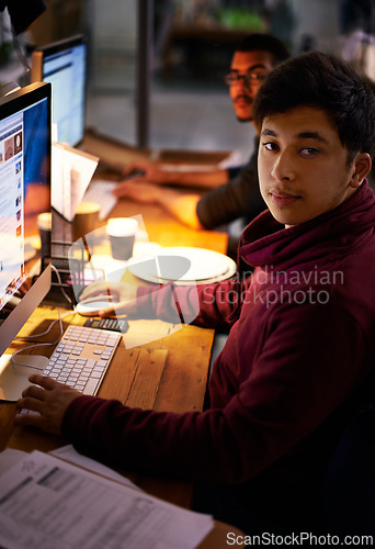Image of Portrait, student and desk with computer at night to study with calculator for maths test or accounting exam. Male person, serious and laptop with paperwork for assessment or assignment, online work