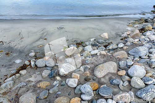 Image of Serene beachscape with pebbled shoreline and gentle waves at twi