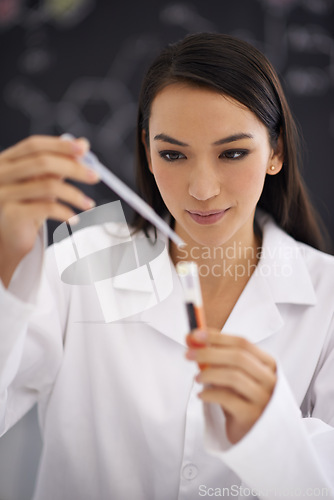 Image of Scientist, woman and dropper in test tube for research, experiment or biology with red liquid in laboratory. Science, medical professional and pipette for sample analysis of blood, dna and chemistry