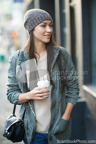 Image of Woman, fashion and denim with coffee, travel and city street or background for style. Asian student, beanie and jacket in cape town with winter, cold and adventure with urban holiday for confidence