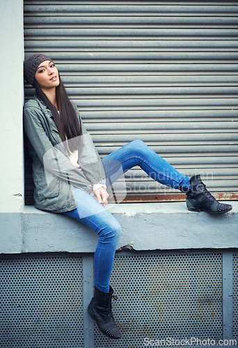 Image of Woman, fashion and jeans with portrait, urban and city street or background for style. Female student, beanie and jacket in cape town with winter, cold and lazy with metal garage door for confidence