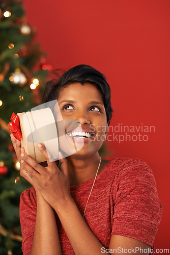 Image of Christmas, excited and woman guess gift in box at home for holiday celebration on mockup space in India. Happy person, xmas and shaking present or listening to package for festive season in house