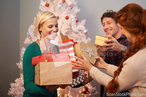Image of Friends, Christmas and gift giving at tree for festive season celebration with present, vacation or together. Man, women and parcel event in living room for winter break or excited, bonding or love