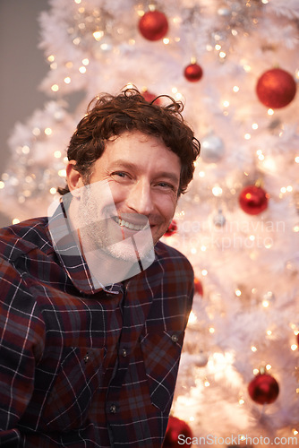 Image of Portrait, Christmas and man with smile, home and happiness with decorations and festive season. Face, Xmas tree and apartment with celebration and excited with guy and cheerful with lights or person