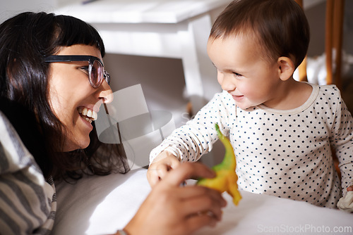 Image of Mother, love and kid with toy in bedroom, play and happy for childhood in home on bed. Mommy, daughter and security in connection or trust, child development and relax on weekend for bonding