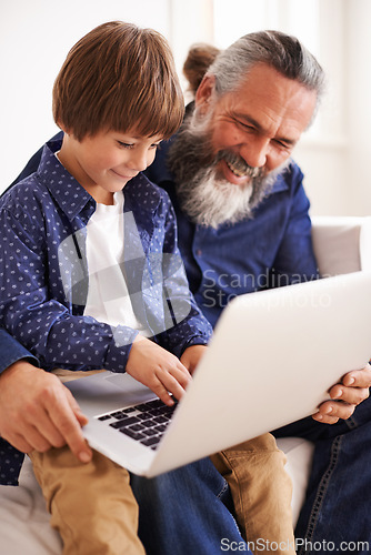 Image of Grandfather, laptop and boy child for streaming, elearning and bonding in living room. Focus, family and internet for play and son typing, childhood development and games or technology for learning