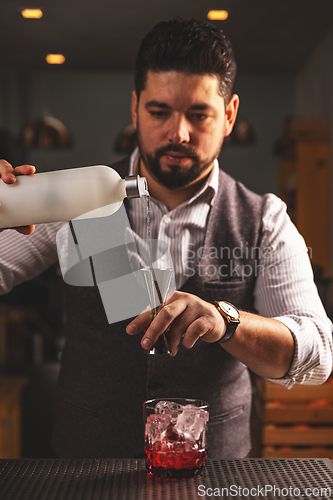 Image of Expert bartender pouring a cocktail