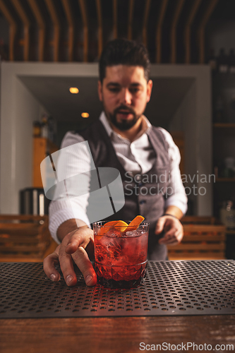 Image of Bartender serving a craft cocktail at a bar