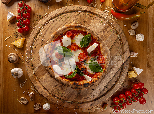 Image of Delicious pizza surrounded by fresh ingredients