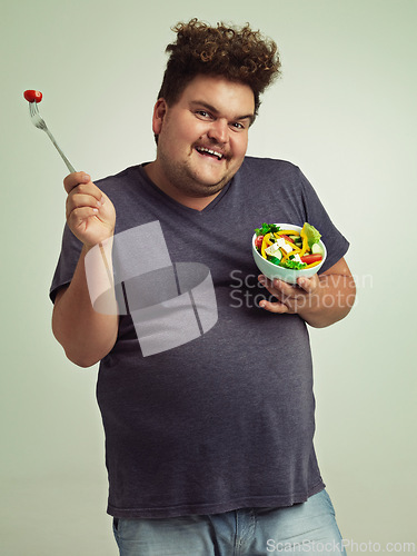 Image of Studio, portrait and overweight man with salad for weight loss, diet and healthy meal with nutrition. Obese, male person and smile with organic food for detox, lifestyle change and vitamin c benefits