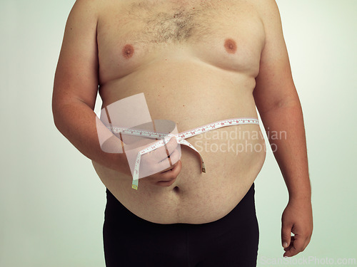 Image of Man, plus size and body with measurement in studio on white background with tape for progress, weight loss and exercise. Positivity, fitness and stomach with self care to monitor health and shape