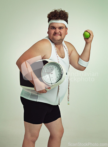 Image of Scale, man and portrait with apple for health, fitness or nutrition isolated on gray studio background mockup. Plus size, body and eating fruit for weight loss diet of male person with tape measure