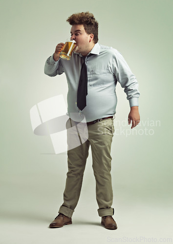 Image of Man, face and drinking with beer for party or chug in obesity on a studio background. Young male person or plus size model with glass, mug or alcohol in satisfaction for brew or booze on mockup space