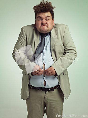 Image of Overweight, portrait and man fitting in shirt, studio and employee with stomach for clothes. Plus size, male person and guy with obesity unhappy with fat of belly in suit for professional job