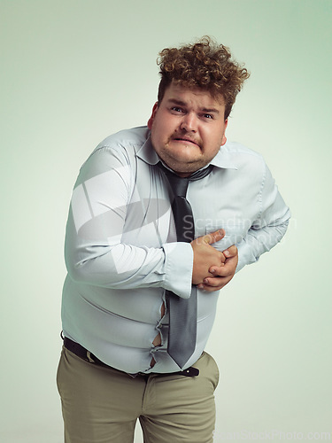 Image of Man, portrait and plus size with heart attack, cardiac arrest or ache on a studio background. Frustrated male person or big model with body pain or cholesterol in unhealthy weight on mockup space
